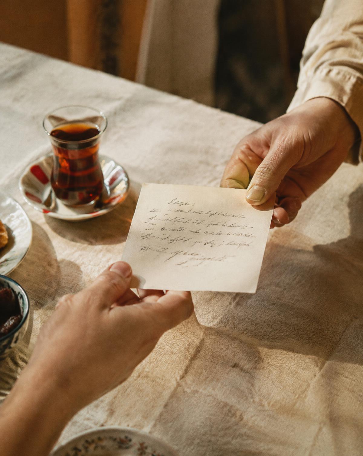 A handwritten note passed over a table
